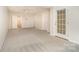 Spacious, brightly lit room with neutral carpet, white walls, and access to outdoor space through a glass door at 243 Lincoln St, Charlotte, NC 28203