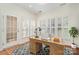 Well-lit home office with a wooden desk, shuttered windows, and hardwood floors at 243 Lincoln St, Charlotte, NC 28203