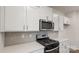 Close-up of modern stainless steel appliances and quartz countertops with a gray tile backsplash at 2605 Goose Fair Rd, Maiden, NC 28650