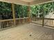 New wooden back porch with railings overlooking a dense forest view at 2924 Noritake Trl # 67, Albemarle, NC 28001