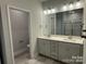 Bathroom with double sink vanity, tiled floors, walk-in shower, and a large mirror with contemporary lighting at 2924 Noritake Trl # 67, Albemarle, NC 28001