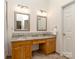 Bathroom with double sinks, granite counters, wooden cabinets, and decorative tiling at 3066 Orion Dr, Fort Mill, SC 29707