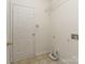 Clean laundry area with a white door, shelf, and hookups on a tiled floor at 3066 Orion Dr, Fort Mill, SC 29707
