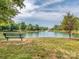 Picturesque pond view with a bench and fountain, surrounded by lush green grass and trees at 3066 Orion Dr, Fort Mill, SC 29707