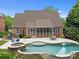Beautiful backyard featuring a luxurious swimming pool, hot tub, patio, and screened porch for outdoor entertaining at 310 E Waterlynn Rd, Mooresville, NC 28115