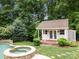 Backyard features shed, pool, spa, patio with furniture, green grass, and trees at 310 E Waterlynn Rd, Mooresville, NC 28115