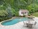 Beautiful backyard including an in-ground pool, spa, patio, shed, and lush landscaping at 310 E Waterlynn Rd, Mooresville, NC 28115