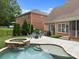 Backyard features pool, patio, spa, fire pit and seating with mature trees at 310 E Waterlynn Rd, Mooresville, NC 28115