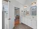 Bright bathroom with double sinks, quartz countertops, wood flooring, and an entry to the main bedroom at 310 E Waterlynn Rd, Mooresville, NC 28115