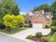 Lovely two-story brick home boasts a well-manicured lawn and a convenient two-car garage at 310 E Waterlynn Rd, Mooresville, NC 28115