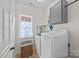 Bright laundry room featuring a side-by-side washer and dryer, storage cabinet, and a window at 310 E Waterlynn Rd, Mooresville, NC 28115