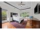 Bright main bedroom featuring hardwood floors, tray ceilings and large windows overlooking a lush landscape at 310 E Waterlynn Rd, Mooresville, NC 28115