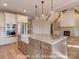 Open-concept kitchen with stainless appliances, farmhouse sink, and island that opens up to the spacious living area at 3439 Stags Leap Way, York, SC 29745