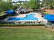 Fenced community pool with shade umbrellas and lounge chairs surrounded by landscaping at 3446 Broadwick St, Charlotte, NC 28213
