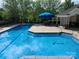 Outdoor community pool with lounge chairs and picnic area with umbrella at 3446 Broadwick St, Charlotte, NC 28213