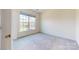 A bright, carpeted bedroom with a large window that offers natural light and neighborhood views at 3719 Wave Rock Ct, Fort Mill, SC 29707