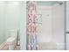 This bathroom features a tub with white tile, a patterned shower curtain, and an updated toilet at 3810 Selwyn Farms Ln # 3, Charlotte, NC 28209