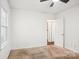 Minimalist bedroom with carpet, a window, and an open doorway at 3810 Selwyn Farms Ln # 3, Charlotte, NC 28209