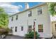 The back exterior of this two-story home features white siding and multiple windows, surrounded by green landscaping at 3810 Selwyn Farms Ln # 3, Charlotte, NC 28209