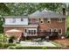 Brick and white siding home featuring a patio, deck, lush landscaping, and a well-maintained lawn at 3909 Black Sycamore Dr, Charlotte, NC 28226