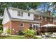 Brick and white siding home featuring a deck, lush landscaping, and a well-maintained lawn at 3909 Black Sycamore Dr, Charlotte, NC 28226