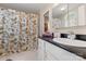 Well-lit bathroom featuring a floral shower curtain, single sink with black countertop, and a mirrored vanity at 3909 Black Sycamore Dr, Charlotte, NC 28226