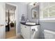 Well-lit bathroom with modern vanity, black countertop, and framed mirror next to the toilet at 3909 Black Sycamore Dr, Charlotte, NC 28226