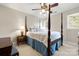 Comfortable bedroom features a four-poster bed, neutral carpet, and a ceiling fan with lights at 3909 Black Sycamore Dr, Charlotte, NC 28226
