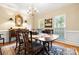 Traditional dining room with a wooden table, chandelier, and large windows providing natural light for Gathering gatherings at 3909 Black Sycamore Dr, Charlotte, NC 28226