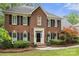 Classic brick home featuring black shutters, a well-manicured lawn, and a welcoming front entrance at 3909 Black Sycamore Dr, Charlotte, NC 28226