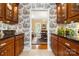 Detailed kitchen featuring rich wood cabinetry, black granite countertops, and unique wallpaper leading to a dining area at 3909 Black Sycamore Dr, Charlotte, NC 28226