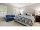 Bright main bedroom with shuttered windows, a comfortable blue sofa, and a bed adorned with a patterned blue duvet at 3909 Black Sycamore Dr, Charlotte, NC 28226