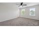 Bright bedroom featuring two windows and neutral carpeting at 392 Winecoff Woods Nw Dr, Concord, NC 28027