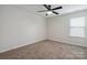 Cozy bedroom features neutral walls, carpet floors, a ceiling fan, and plenty of natural light from the window at 392 Winecoff Woods Nw Dr, Concord, NC 28027