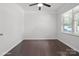 A bright bedroom featuring hard wood floors, a modern ceiling fan, a large window, and neutral paint at 392 Winecoff Woods Nw Dr, Concord, NC 28027