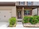 Attractive home exterior with a brick-accented front porch, well-maintained landscaping, and a two-car garage on the side at 392 Winecoff Woods Nw Dr, Concord, NC 28027