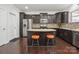 Kitchen featuring dark cabinets, granite countertops, stainless steel appliances, and eat-in island at 392 Winecoff Woods Nw Dr, Concord, NC 28027