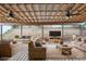 Inviting covered patio with comfortable seating, ceiling fans, and a view of the backyard's natural slope at 392 Winecoff Woods Nw Dr, Concord, NC 28027