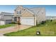 Side view of a two-story home featuring a spacious two-car garage and verdant lawn at 3985 Village Nw Blvd, Conover, NC 28613