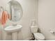 Powder room with pedestal sink, oval mirror, and toilet at 3985 Village Nw Blvd, Conover, NC 28613