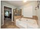 Bright bathroom featuring a soaking tub with a tiled surround and separate glass-enclosed shower at 4018 Harmattan Dr, Denver, NC 28037