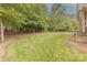 Spacious backyard featuring a lush lawn, mature trees, and a wooden fence at 4113 Hoffmeister Dr, Waxhaw, NC 28173