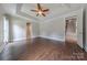 Open bedroom leading to a staircase, tray ceiling, fan and large windows at 4113 Hoffmeister Dr, Waxhaw, NC 28173