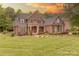 Beautiful brick home with a well-manicured lawn and tasteful landscaping against the sunset at 4113 Hoffmeister Dr, Waxhaw, NC 28173