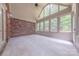 Bright sunroom featuring brick walls, large windows with backyard views, and tile flooring at 4113 Hoffmeister Dr, Waxhaw, NC 28173