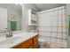 Bathroom offers a wood vanity with a white sink, and a bright shower with a patterned curtain at 5359 Lake Glenn Dr, Stanfield, NC 28163