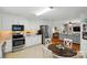 Bright kitchen featuring stainless steel appliances, a dining table, and an open view to the living room at 5359 Lake Glenn Dr, Stanfield, NC 28163
