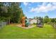Beautiful play set and trampoline sit in a lush backyard with plenty of room to play at 5359 Lake Glenn Dr, Stanfield, NC 28163