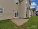 The backyard has a concrete patio area just outside the door with grass surrounding it at 5607 Fulton Ridge Dr, Indian Trail, NC 28079