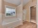 Bright bathroom with a soaking tub under a window and a separate glass-enclosed shower at 5607 Fulton Ridge Dr, Indian Trail, NC 28079